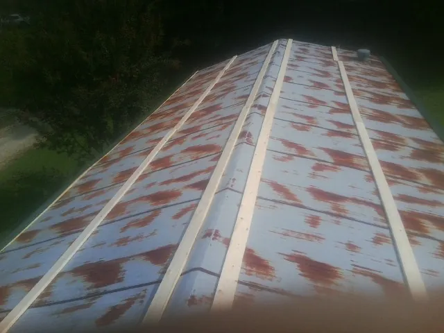 Rusted metal roof panels with new wood purlins before replacement — Storm Damage Roof Repair in Boothbay Harbor by Roofing Brothers