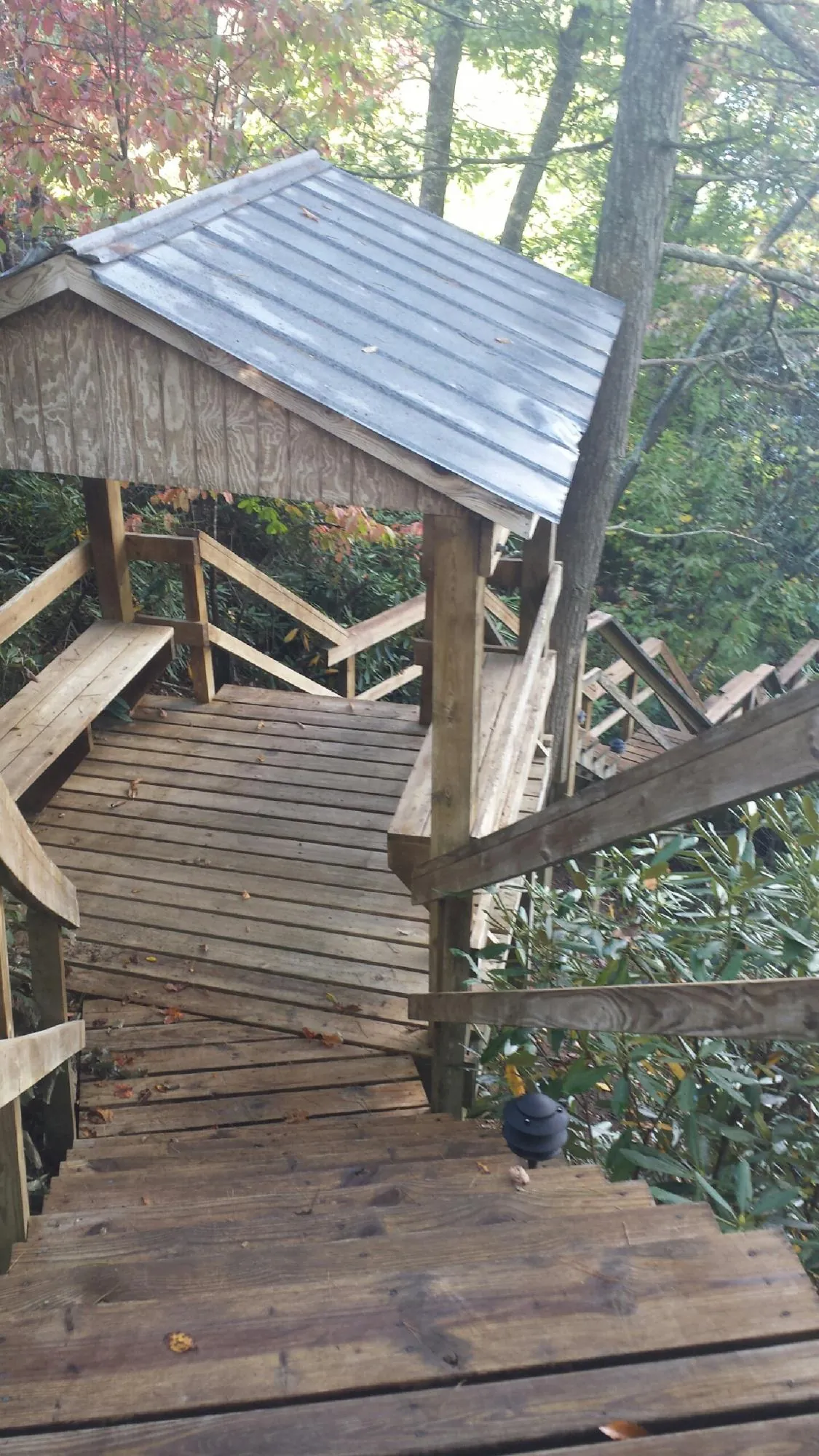Metal roofed shelter over wooden steps on a wooded walkway — Skylight Repair & Installation work by our crew in Boothbay Harbor