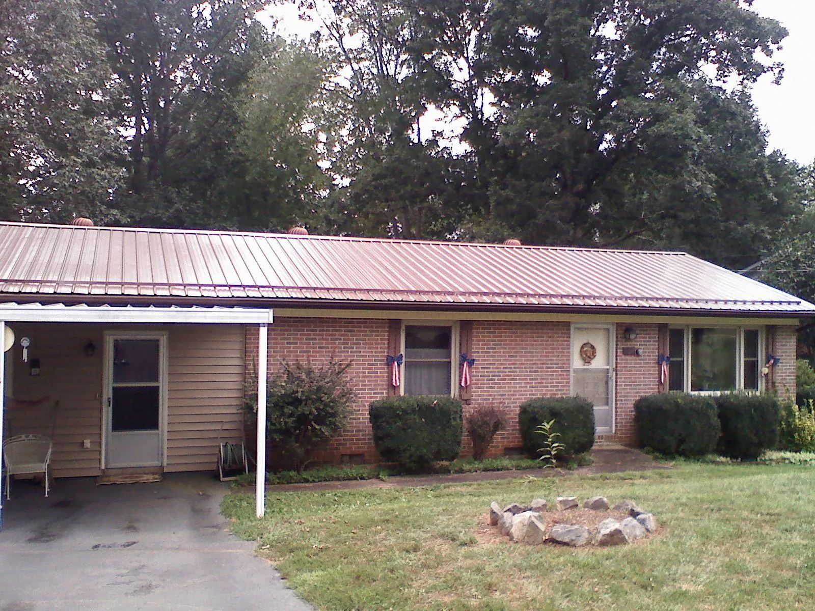 Bronze metal roof and carport on a brick ranch home — Roof Repair work by our crew in Boothbay Harbor